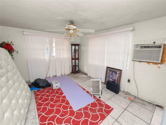 bedroom with ceiling fan, an AC wall unit, and radiator heating unit