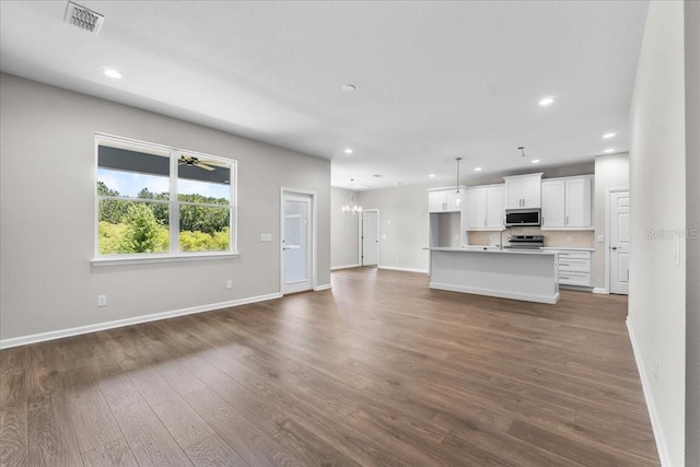 unfurnished living room with recessed lighting, visible vents, baseboards, and dark wood-type flooring