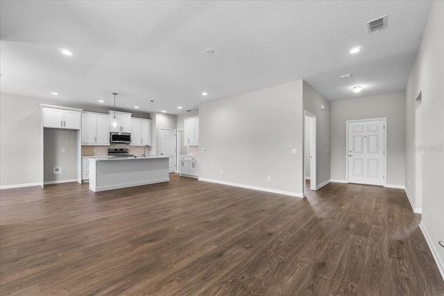 unfurnished living room featuring visible vents, dark wood-type flooring, and recessed lighting
