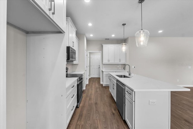 kitchen featuring dark wood finished floors, light countertops, dishwasher, a sink, and black electric range oven