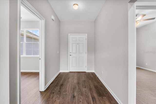 hallway featuring dark wood-style floors and baseboards