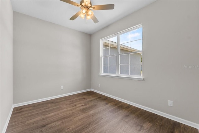 empty room featuring baseboards, a ceiling fan, and dark wood-style floors