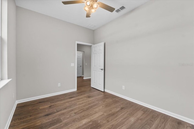 unfurnished bedroom with visible vents, ceiling fan, wood finished floors, and baseboards
