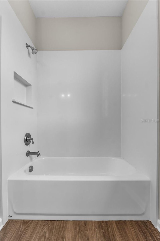 full bath with shower / bath combination and wood finished floors