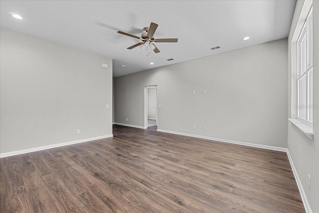 empty room featuring visible vents, ceiling fan, wood finished floors, and baseboards