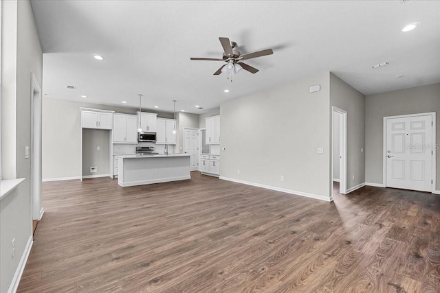 unfurnished living room featuring recessed lighting, ceiling fan, baseboards, and dark wood finished floors