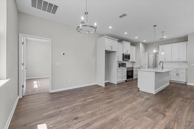 kitchen featuring dark wood-style flooring, visible vents, stainless steel appliances, and light countertops
