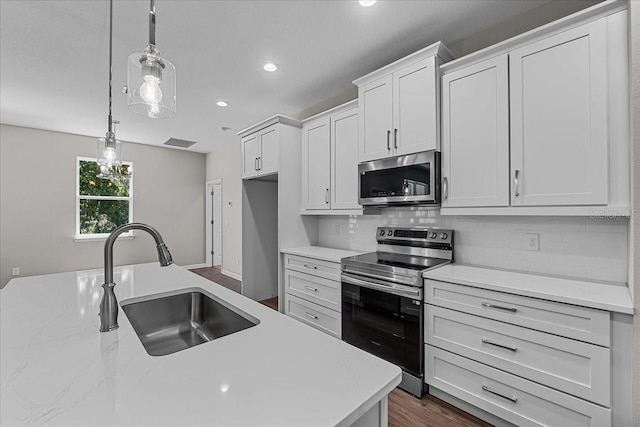 kitchen featuring recessed lighting, a sink, decorative backsplash, stainless steel appliances, and visible vents