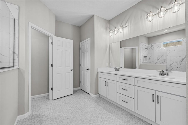 bathroom featuring double vanity, baseboards, a shower, and a sink