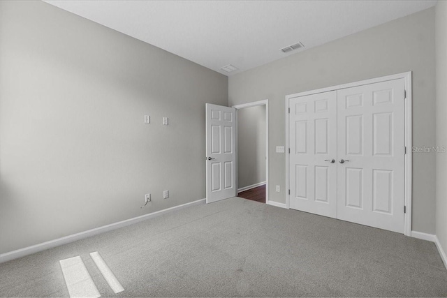 unfurnished bedroom with a closet, visible vents, carpet, and baseboards