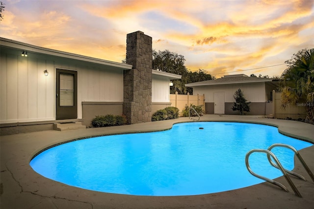 pool at dusk featuring a patio area