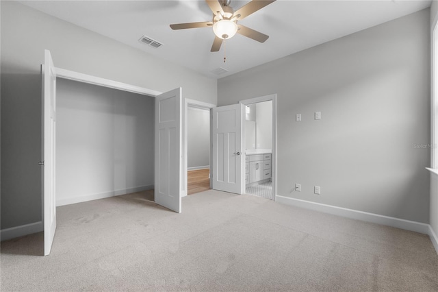 unfurnished bedroom featuring connected bathroom, a closet, carpet flooring, baseboards, and visible vents
