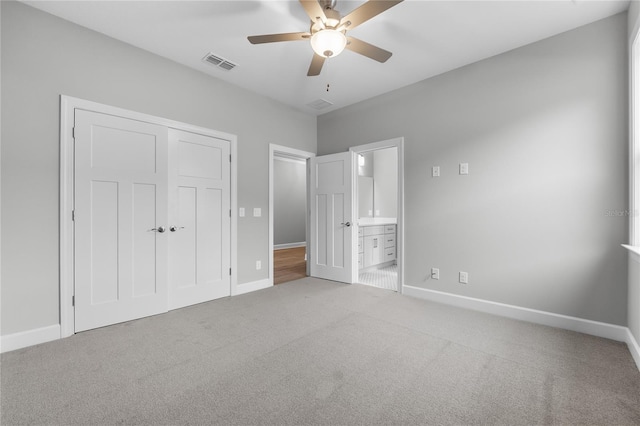 unfurnished bedroom featuring a closet, carpet flooring, visible vents, baseboards, and ensuite bath