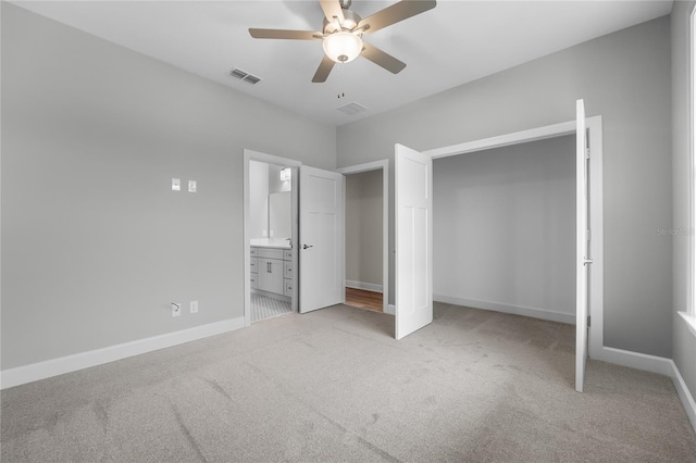 unfurnished bedroom featuring connected bathroom, baseboards, light colored carpet, and visible vents