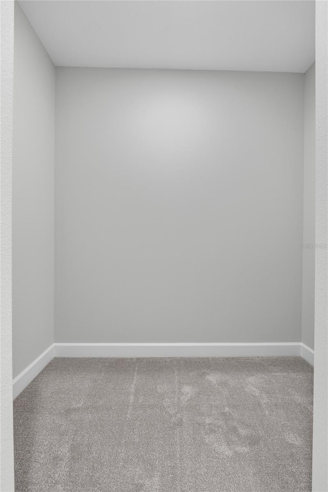 carpeted spare room featuring baseboards