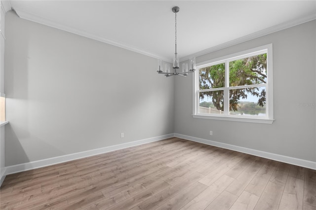unfurnished room featuring light wood finished floors, baseboards, ornamental molding, and a chandelier