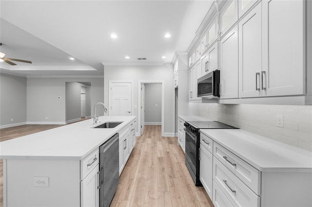kitchen with backsplash, a sink, light wood finished floors, visible vents, and appliances with stainless steel finishes