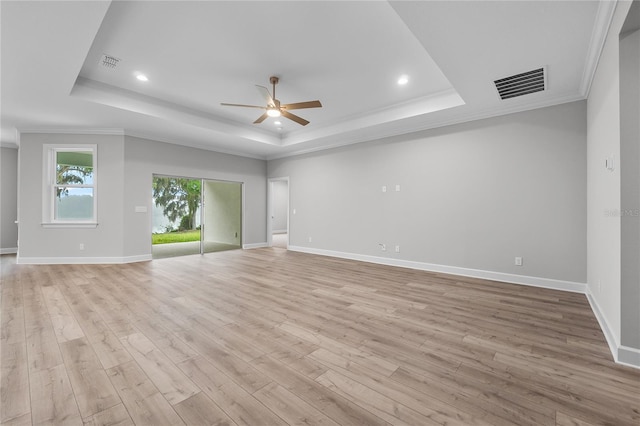 empty room with a tray ceiling, visible vents, and a ceiling fan