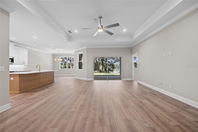 4537 Fairway Oaks Dr, Mulberry, FL 33860 - unfurnished living room with a healthy amount of sunlight, light wood finished floors, and a raised ceiling