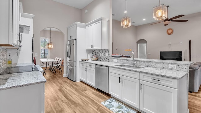 kitchen featuring backsplash, sink, appliances with stainless steel finishes, light hardwood / wood-style flooring, and white cabinets