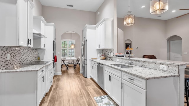 kitchen featuring a breakfast bar, sink, tasteful backsplash, and light hardwood / wood-style flooring