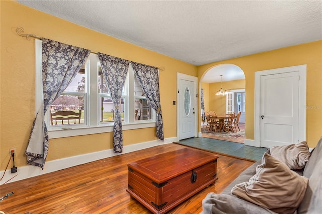 living room featuring a healthy amount of sunlight, wood-type flooring, and a textured ceiling