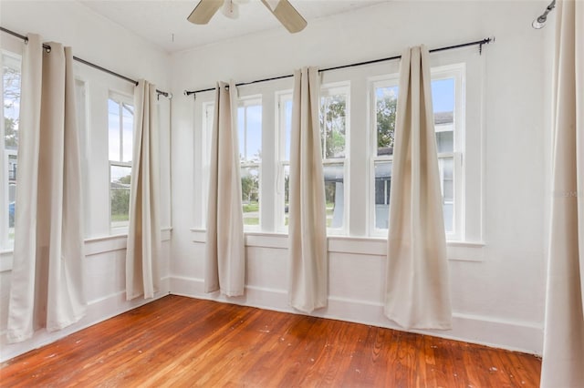 unfurnished sunroom with ceiling fan