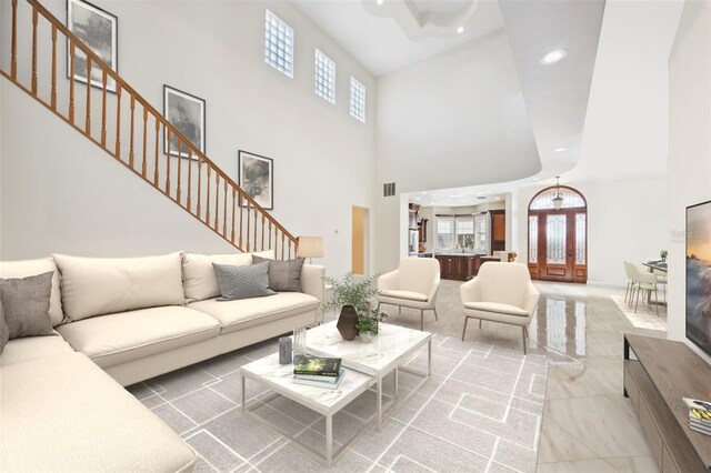 living room with a healthy amount of sunlight, visible vents, stairway, and french doors