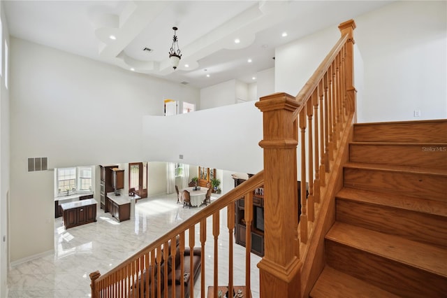 stairway featuring a high ceiling, an inviting chandelier, visible vents, and recessed lighting