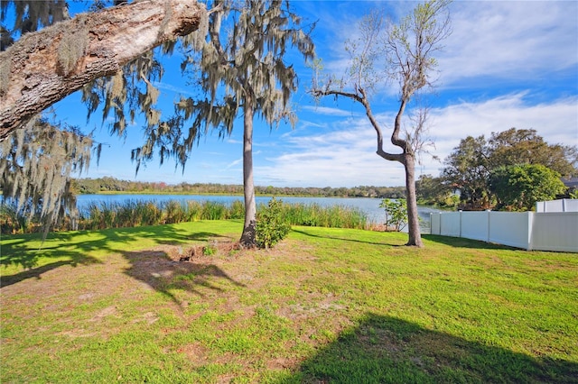 view of yard with a water view and fence