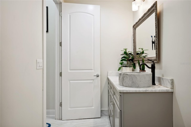 bathroom with marble finish floor and vanity