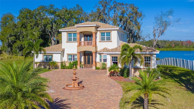 mediterranean / spanish-style house with a front lawn and a balcony