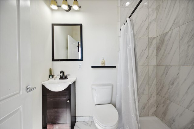 bathroom featuring marble finish floor, a tile shower, vanity, and toilet