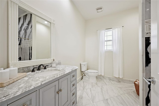 full bath featuring toilet, marble finish floor, baseboards, and vanity