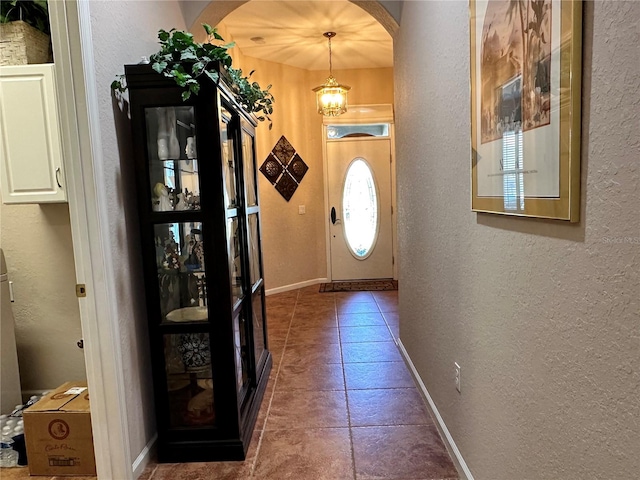 entryway featuring a notable chandelier and tile flooring