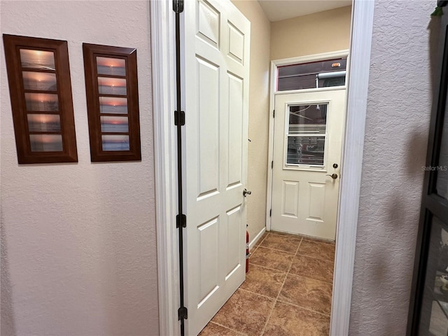 hall featuring dark tile floors