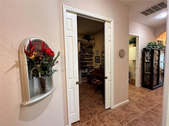 corridor with dark tile floors