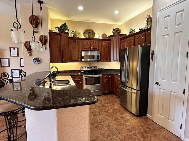 kitchen with kitchen peninsula, appliances with stainless steel finishes, dark tile flooring, dark brown cabinetry, and sink