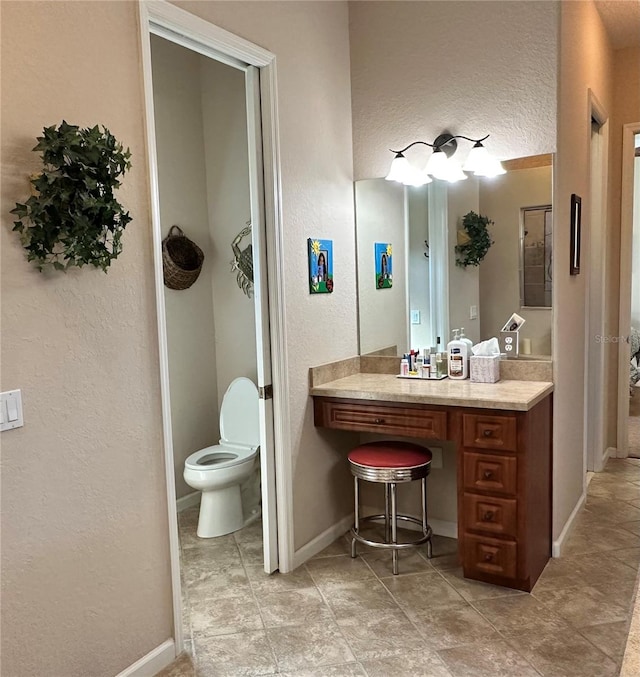 bathroom with toilet, tile floors, and vanity with extensive cabinet space