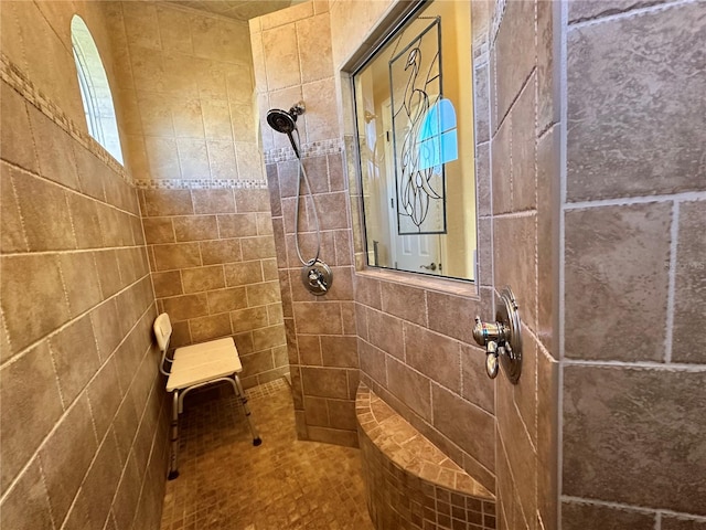 bathroom with tile walls and a tile shower