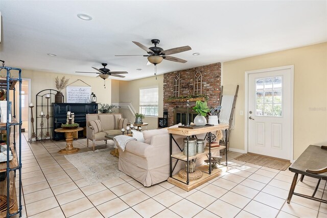 tiled living room with ceiling fan and a brick fireplace