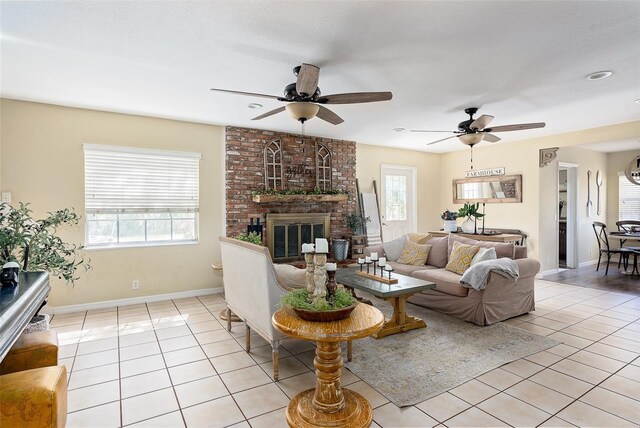 living room with light tile patterned floors, ceiling fan, and a brick fireplace