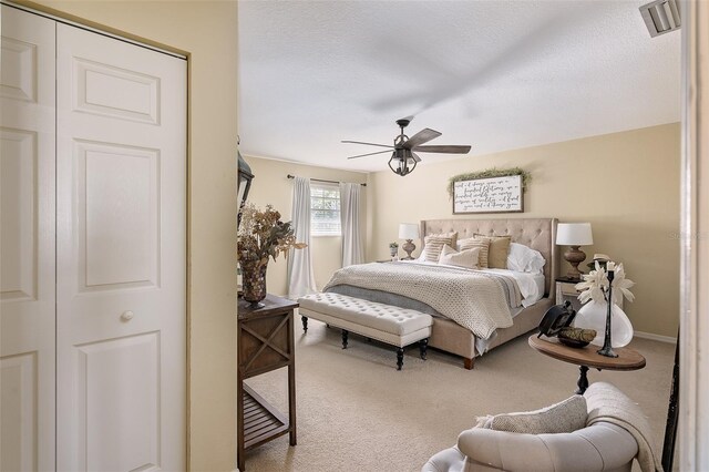 bedroom with a textured ceiling, carpet floors, and ceiling fan