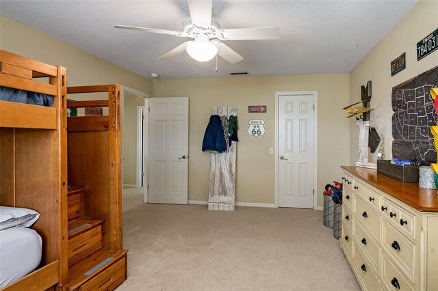 carpeted bedroom with a textured ceiling and ceiling fan