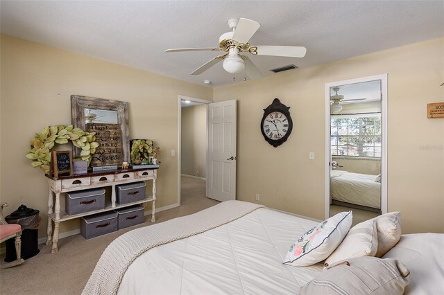 bedroom featuring ceiling fan, a textured ceiling, and light colored carpet