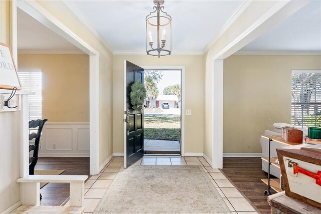 tiled foyer featuring a notable chandelier and crown molding