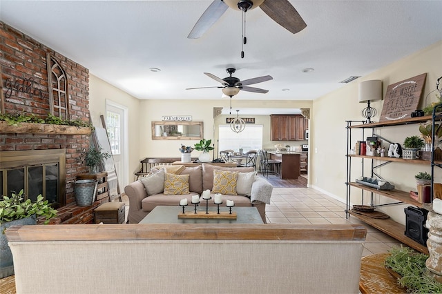 tiled living room featuring a fireplace and ceiling fan