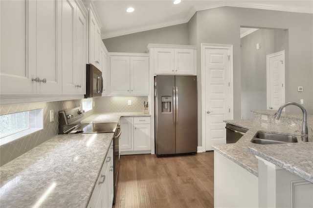 kitchen with light stone countertops, appliances with stainless steel finishes, white cabinetry, sink, and backsplash