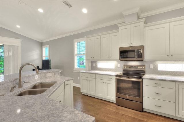 kitchen with hardwood / wood-style flooring, stainless steel appliances, white cabinetry, and sink