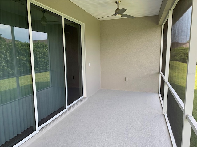 unfurnished sunroom featuring ceiling fan